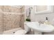 Cozy bathroom with tiled shower, pedestal sink, decorative mirror, and neutral color palette at 14432 N 39Th Way, Phoenix, AZ 85032