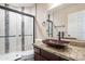Bathroom with a granite countertop, dark wood cabinets, vessel sink, and decorative tiled shower at 14443 W Morning Star Trl, Surprise, AZ 85374
