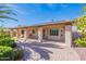 Exterior view of the covered patio with solar panels, lush landscaping, and brick-paved patio at 14443 W Morning Star Trl, Surprise, AZ 85374