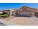 Charming single-story home featuring a private courtyard and brick-paved driveway leading to an attached two-car garage at 14443 W Morning Star Trl, Surprise, AZ 85374