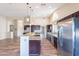 Modern kitchen with granite countertops, stainless steel appliances, pendant lighting, and a large center island at 14443 W Morning Star Trl, Surprise, AZ 85374