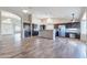 Open-concept kitchen and living area featuring modern appliances, granite countertops, and wood-look tile flooring at 14443 W Morning Star Trl, Surprise, AZ 85374