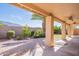 Covered patio overlooks a well-manicured backyard with lush landscaping and a tall palm tree at 14443 W Morning Star Trl, Surprise, AZ 85374