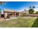 Backyard with a hot tub, covered patio, barbecue, and large grass area at 1569 E Princeton Ave, Gilbert, AZ 85234