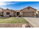 Well-maintained home features desert landscaping, a two-car garage, and a cozy front yard with green grass at 1569 E Princeton Ave, Gilbert, AZ 85234