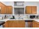 Traditional kitchen showcasing wooden cabinetry, dual basin sink, and natural light from a large window at 1569 E Princeton Ave, Gilbert, AZ 85234