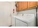 Laundry room with a washer, dryer, and wood cabinets for storage at 1569 E Princeton Ave, Gilbert, AZ 85234