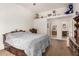 Spacious bedroom with carpet, ceiling fan, and a partial wall to display decorations and a view of the ensuite bathroom at 1569 E Princeton Ave, Gilbert, AZ 85234