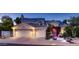 Charming home featuring a three-car garage, solar panels, and inviting entrance with lush landscaping at twilight at 1614 E Kathleen Rd, Phoenix, AZ 85022