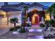 Inviting home entrance with a decorative archway, illuminated walkway, and lush landscaping adding charm at 1614 E Kathleen Rd, Phoenix, AZ 85022