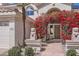 Welcoming front entrance adorned with vibrant bougainvillea and a charming stone statue at 1614 E Kathleen Rd, Phoenix, AZ 85022