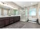 A luxurious bathroom featuring a glass shower, soaking tub, and dual sink vanity at 1620 E Cloud Rd, Phoenix, AZ 85086