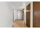 Bright hallway with laminate flooring, interior doors, and decorative lighting, offering a glimpse of the front door at 16827 N 103Rd Ave, Sun City, AZ 85351