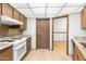 A spacious kitchen featuring wood cabinetry, neutral countertops, and white appliances at 16827 N 103Rd Ave, Sun City, AZ 85351