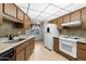 A kitchen featuring light wood cabinetry, a neutral countertop, tile backsplash, and laminate flooring at 16827 N 103Rd Ave, Sun City, AZ 85351