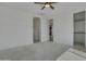 Spacious bedroom with plush carpeting, ceiling fan, and a view of a walk-in closet at 17033 W Royal Palm Rd, Waddell, AZ 85355