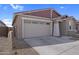 Single-story home featuring a two-car garage and xeriscaping at 17033 W Royal Palm Rd, Waddell, AZ 85355