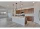 Kitchen with island and modern pendant lights with stainless steel appliances and ample cabinet space at 17033 W Royal Palm Rd, Waddell, AZ 85355