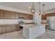 A modern kitchen featuring a large island, stainless steel appliances and pendant lighting at 17033 W Royal Palm Rd, Waddell, AZ 85355