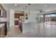 Open kitchen featuring an island with bar seating, cabinets and pendant lights above at 17033 W Royal Palm Rd, Waddell, AZ 85355