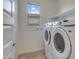 Laundry room featuring a new washer and dryer, and a window bringing in natural light at 17033 W Royal Palm Rd, Waddell, AZ 85355