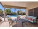 Comfortable back patio with furniture, a view of the sparkling pool, and a lush garden at 17246 N 56Th Way, Scottsdale, AZ 85254