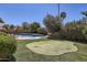 Back yard featuring a pool and putting green surrounded by lush landscaping and trees at 17246 N 56Th Way, Scottsdale, AZ 85254