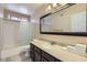 Bathroom features a shower and bathtub combination with sliding doors, a large mirror, and neutral tiling at 17246 N 56Th Way, Scottsdale, AZ 85254
