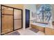 Bathroom featuring a glass shower, a soaking tub under an arched window and neutral colors at 17246 N 56Th Way, Scottsdale, AZ 85254