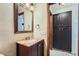 Bathroom featuring vanity with stone countertop, dark wood cabinets, and a framed mirror and stylish lighting fixtures at 17246 N 56Th Way, Scottsdale, AZ 85254