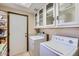 Bright laundry room with white cabinets, a washer and dryer, and a door leading to the outside at 17246 N 56Th Way, Scottsdale, AZ 85254