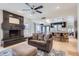 Open concept living room and kitchen with a fireplace, comfortable seating, and travertine flooring throughout at 17246 N 56Th Way, Scottsdale, AZ 85254