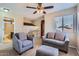 The living room has neutral walls and carpet, a ceiling fan, and modern sofas. Stairs with metal railings lead to the second floor at 17246 N 56Th Way, Scottsdale, AZ 85254