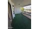 Large balcony with green carpet, door, and decorative wall feature at 17404 N 99Th Ave # 214, Sun City, AZ 85373