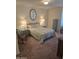 Serene bedroom with a queen-sized bed, elegant lamps, and a decorative mirror at 17404 N 99Th Ave # 214, Sun City, AZ 85373