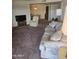Carpeted living room showing a sofa, chair, and access to the dining area at 17404 N 99Th Ave # 214, Sun City, AZ 85373