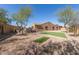Large backyard featuring a grass area and plenty of space for activities surrounded by lush trees and privacy at 17953 W Willow Dr, Goodyear, AZ 85338