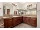 Bathroom featuring double vanity, decorative mirrors, and neutral tile flooring at 17953 W Willow Dr, Goodyear, AZ 85338