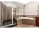 Primary bathroom features separate shower, tub, and neutral tile surround at 17953 W Willow Dr, Goodyear, AZ 85338