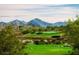 Picturesque golf course view surrounded by mountains and desert landscape with a clear blue sky, perfect for golfing at 17953 W Willow Dr, Goodyear, AZ 85338