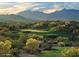Verdant golf course landscape with scenic mountain backdrop, featuring mature trees and meticulously maintained greens at 17953 W Willow Dr, Goodyear, AZ 85338