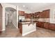 Well-equipped kitchen with tiled floors, wooden cabinets, a granite-topped island, and stainless-steel appliances at 17953 W Willow Dr, Goodyear, AZ 85338