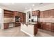 Spacious kitchen featuring a center island with granite countertops, tile floors, and wood cabinetry at 17953 W Willow Dr, Goodyear, AZ 85338