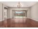 Bright living room with hardwood floors, an elegant chandelier, and sliding doors leading to an outdoor pool at 17953 W Willow Dr, Goodyear, AZ 85338