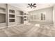 Inviting carpeted living room with a ceiling fan, built-in shelving, and plantation shutters on the windows at 17953 W Willow Dr, Goodyear, AZ 85338