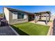 Backyard featuring artificial grass, a patio, a gazebo, and a neutral-toned exterior at 18735 W San Juan Ave, Litchfield Park, AZ 85340