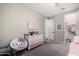 A bedroom with a themed chair and dresser, adjoining a closet with organized clothing at 18735 W San Juan Ave, Litchfield Park, AZ 85340