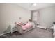 Comfortable bedroom featuring a plush daybed, soft pink accents, and a window creating a peaceful and inviting atmosphere at 18735 W San Juan Ave, Litchfield Park, AZ 85340