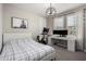 Cozy bedroom with a modern light fixture, desk, and a large window that offers natural light and a relaxing space at 18735 W San Juan Ave, Litchfield Park, AZ 85340