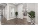 Hallway with a decorative mirror and potted plants, leading to a doorway with views to playroom at 18735 W San Juan Ave, Litchfield Park, AZ 85340